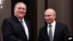 Russian President Vladimir Putin, right, and U.S. Secretary of State Mike Pompeo, pose for a photo before their talks in the Black Sea resort city of Sochi, southern Russia, May 14, 2019. 