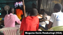 Young men watch sport on a small television in a makeshift viewing hall in UNMISS's Tongping Protection of Civilians site in Juba.