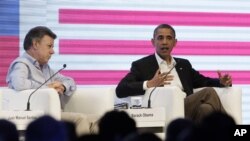Prezidan Kolonbi a, Juan Manuel Santos (a goch) chita bò kote Prezidan Barack Obama nan Somè Dèzamerik la, nan Katajèn, Kolonbi, samdi 14 avril 2012. (Foto AP/Carolyn Kaster)