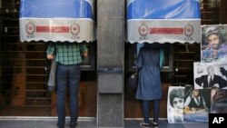 FILE - Iranians use ATM machines of Bank Melli Iran in downtown Tehran, Iran, April 4, 2015. 