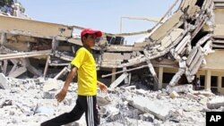 A child walks past the rubble of a university building in Zlitan, Libya, August 4, 2011