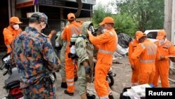 Anggota Pasukan Tanggap Bencana Nasional (NDRF) mengenakan alat pelindung diri di lokasi kebocoran gas di Ludhiana di negara bagian utara Punjab, India, 30 April 2023. (Foto: Reuters)