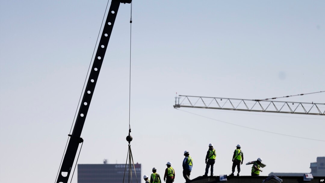 FILE - Construction workers unload supplies off a hoisted pallet on a rooftop in Atlanta, June 7, 2016. Workers' productivity increased in the third quarter at a 3.1 percent rate, the Labor Department reported Dec. 6, 2016.