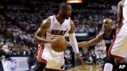 Dwyane Wade du Miami Heat, à gauche, contre Gerald Henderson des Charlotte Bobcats, Miami, le 23 avril 2014. 