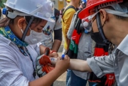 An anti-coup protester writes emergency information of another protester on his arm in Yangon, Myanmar, March 3, 2021.