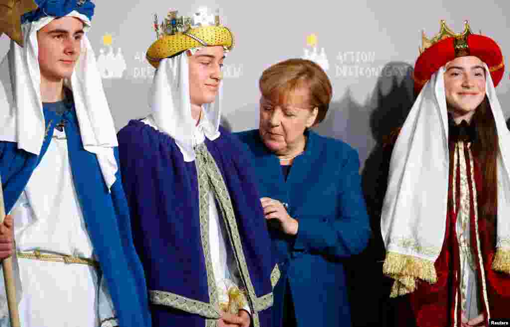 German Chancellor Angela Merkel meets carol singers during a reception at the German Chancellery in Berlin.