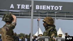 A French soldier, left, salutes an Ivorian soldier as the French soldiers prepare to leave Camp Thomas d'Aquin Ouattara, the former French 43rd Marine Infantry Battalion base in Port-Bouet in Abidjan on Feb. 20, 2025.