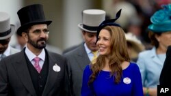 FILE - Sheikh Mohammed bin Rashid al-Maktoum and his wife Princess Haya of Jordan walk towards the paddock on the second day of Royal Ascot horse race meeting at Ascot, England, June 20, 2012. 