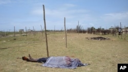 FILE - The lifeless body of a man is covered with a shroud as it lies in an open field in Kismayo, Somalia. Inter-clan violence killed six people Saturday in Labi-Aano village, 45 km east of Dhuusamareeb, Somalia. 