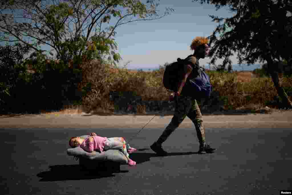 A migrant pulls a girl lying on a cart, following a fire at the Moria camp on the island of Lesbos, Greece.