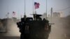 FILE - A convoy of U.S. forces drives near the village of Yalanli, on the western outskirts of the northern Syrian city of Manbij, March 5, 2017. 