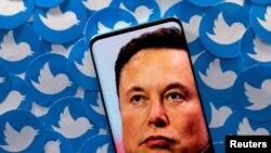 FILE PHOTO: Illustration shows Elon Musk image on smartphone and printed Twitter logos. Taken 4.28.2022