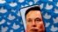 FILE PHOTO: Illustration shows Elon Musk image on smartphone and printed Twitter logos. Taken 4.28.2022