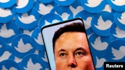 ARCHIVO - La ilustración muestra la imagen de Elon Musk en un teléfono y logos de Twitter detrás.