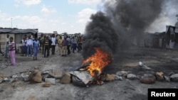 Para pekerja tambang yang mogok membakar ban bekas dan memblokir jalanan di luar pertambangan Anglo American Platinum (Amplats) dekat Rustenburg, 120 kilometer sebelah barat laut Johannesburg (30/10). Polisi Afsel membubarkan mereka dengan menembakkan gas air mata dan peluru karet.