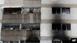 La fumée recouvre les mur du complexe d’appartements où un drone armé s’est écrasé, provoquant un incendie, à Caracas, au Venezuela, le dimanche 5 août 2018. 