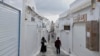 Tourists pass by closed shops in Fira town as Greek authorities are taking emergency measures in response to intense seismic activity on the popular Aegean Sea holiday island of Santorini, southern Greece, Feb. 3, 2025.