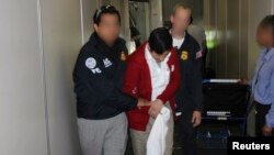 FILE - Special agents with U.S. Immigration and Customs Enforcement's Homeland Security Investigations escort Jorge Sosa, a former Guatemalan army commando, following his extradition from Canada, at Los Angeles International Airport in this handout photo, Sept. 22, 2012.