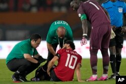 Mohamed Salah dari Mesir menerima perawatan medis saat mengalami cidera pada pertandingan sepak bola Grup B Piala Afrika antara Mesir dan Ghana di Abidjan, Pantai Gading, Kamis, 18 Januari 2024. (AP/Themba Hadebe)