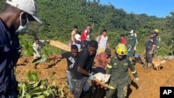 En esta foto distribuida por la Oficina de Prensa del Ejército Colombiano, socorristas hallan el cuerpo de una víctima fatal de un derrumbe vial que dejó decenas de muertos y heridos en el oeste de Colombia, el 13 de enero de 2024.
