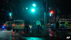 Police attend the scene near Kensington High Street in London, Dec. 11, 2021, where British police say a man was killed during a confrontation with firearms officers near the Kensington Palace royal residence.