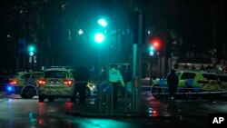 Polisi berjada di sekitar lokasi baku tembak dekat Kensington High Street di London, Sabtu, 11 Desember 2021. Polisi Inggris mengatakan seorang pria tewas dalam baku tembak dengan polisi itu dekat Istana Kensington.