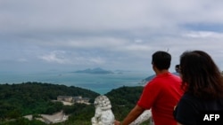 FILE - People look at the view from an observation point in Nangan Township, in the Matsu Islands, Taiwan, on October 15, 2024.