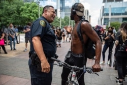 Episodios de violencia registrados en varias ciudades estadounidenses constrastan con imágenes en que es visible el vínculo cordial entre fuerzas del orden y manifestantes en un momento crítico para la nación.