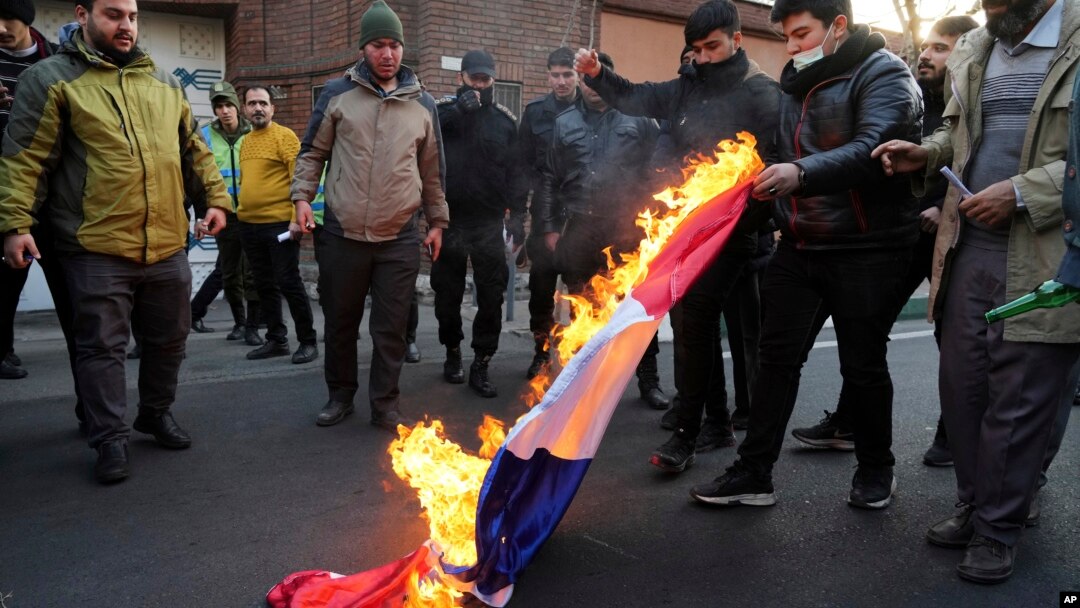 Demonstran Iran membakar bendera Prancis untuk memprotes penerbitan karikatur ofensif Pemimpin Tertinggi Iran Ayatollah Ali Khamenei oleh majalah Charlie Hebdo, dalam aksi di depan Kedubes Prancis di Teheran, Minggu (8/1). 
