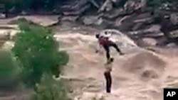 In this July 23, 2017, image taken from video provided by the Pima County Sheriff's office, a stranded hiker is airlifted to safety near Tucson, Arizona.