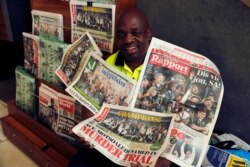 A newspaper seller poses for a photograph on Nov. 3, 2019 in Johannesburg with the banner headlines of South Africa's Rugby World Cup win over England on Saturday. South Africa beat England 32-12.