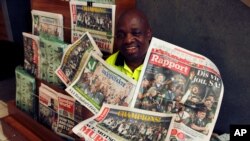 Seorang penjual koran di Johannesburg, Afrika Selatan, berpose dengan barang dagangannya pada 3 November 2019. (Foto: AP/Denis Farrell)