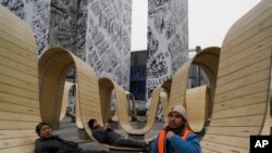 FILE - Young workers rest outside a shopping mall in Beijing, Jan. 17, 2024.