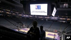 FILE - Fans leave the Golden 1 Center after the NBA basketball game between the New Orleans Pelicans and Sacramento Kings was canceled at the last minute amid coronavirus fears, in Sacramento, California, March 11, 2020. 