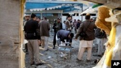 Pakistani security officials examine the site of a suicide attack in Mardan, Pakistan, Dec. 29, 2015.