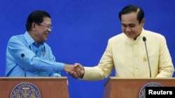 Cambodia's Prime Minister Hun Sen (L) and Thailand's Prime Minister Prayuth Chan-ocha shake hands during a news conference after an agreement signing ceremony at the Government House in Bangkok, Thailand, Dec.19, 2015.