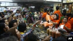 Para pembeli mengerumuni toko makanan yang menjual makanan kering untuk persiapan Ramadan dan Idul Firi di sebuah pasar di Jakarta (14/8/2012). 