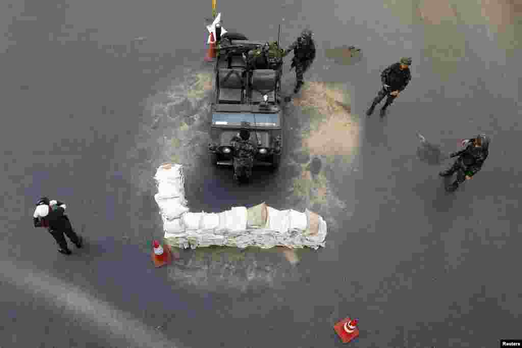 Thai soldiers take their positions in the middle of a main intersection in Bangkok&#39;s shopping district. Thailand&#39;s army declared martial law to restore order after six months of anti-government protests which have left the country without a proper functioning government, but the move did not constitute a coup, military officials said.