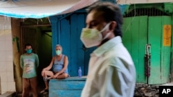 A shopkeeper wearing mask as a precaution against the coronavirus rests outside his closed shop at market in Prayagraj, India, May 9, 2021. 