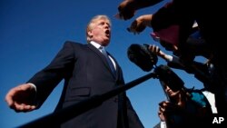 FILE - President Donald Trump speaks with reporters before boarding Air Force One at Morristown Municipal Airport, in Morristown, N.J., Sept. 24, 2017. The Trump administration announced new travel ban restrictions after spending months hashing out the details, determined to avoid a repeat of the chaos of Trump’s first travel ban.