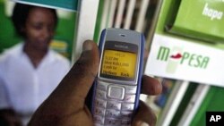 FILE - A man sending money through a mobile phone service called M-Pesa, in Nairobi.