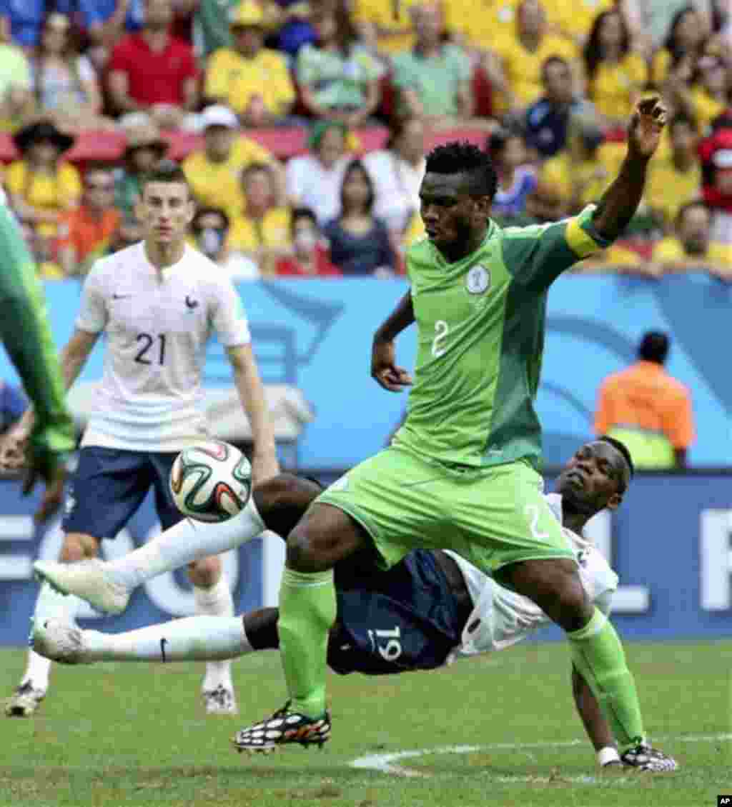 France's Paul Pogba (19) challenges Nigeria's Joseph Yobo (2) during the World Cup round of 16 soccer match between France and Nigeria at the Estadio Nacional in Brasilia, Brazil, Monday, June 30, 2014. (AP Photo/David Vincent)