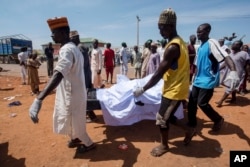 People carry the body of a victim of a tanker explosion for funeral in Majiya town, Nigeria, Oct. 16, 2024.