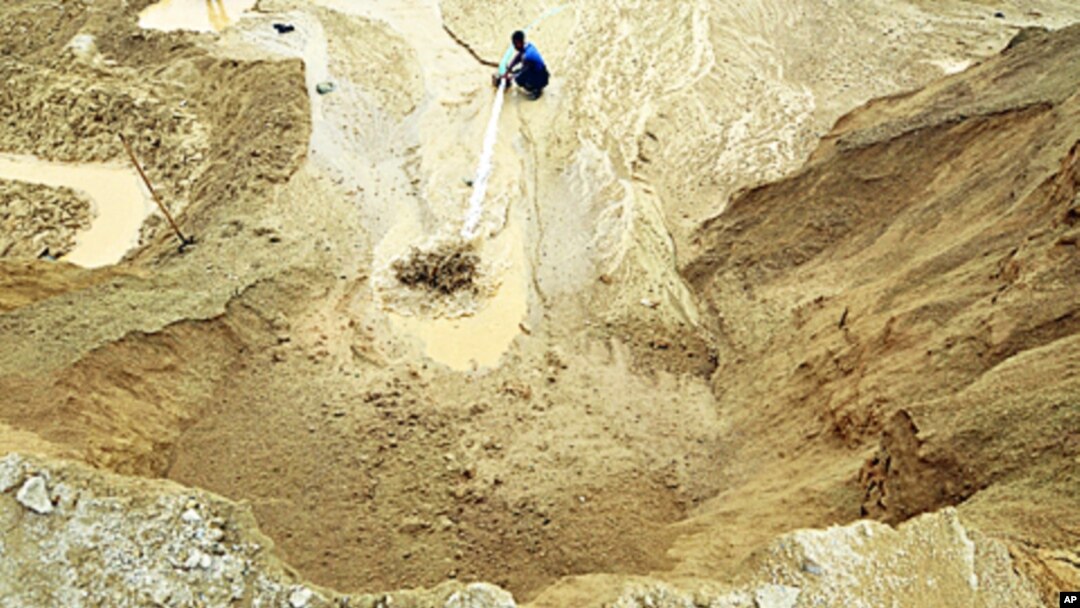 A worker waters the site of a rare earth metals mine at Nancheng county, Jiangxi province, China 29 Dec 2010