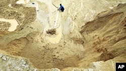 A worker waters the site of a rare earth metals mine at Nancheng county of Jiangxi province, China, 29 Dec 2010