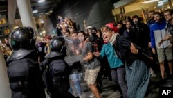 La policía enfrenta a manifestantes durante una protesta en el aeropuerto El Prat, en las afueras de Barcelona, España, el lunes 14 de octubre de 2019, después que la Corte Suprema sentenciara a 12 líderes independentistas catalanes. AP/Bernat Armangue.