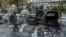 A bystander checks the debris around a row of burnt cars in the suburb of Rinkeby after youths rioted in several different suburbs around Stockholm, May 23, 2013.