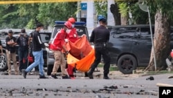 Polisi dan petugas mengangkut potongan tubuh yang diduga dari mayat pembom bunuh diri pasca pemboman di Gereja Katedral Makassar, Minggu (28/3). 