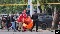  Полицейский и сотрудники спасательной службы рядом с местом взрыва. Макассар, Южное Сулавеси, Индонезия. 28 марта 2021 г. 