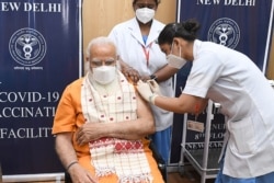 In this photo taken on April 8, 2021, India's Prime Minister Narendra Modi receives the second dose of the Covaxin COVID-19 vaccine, at AIIMS hospital in New Delhi.